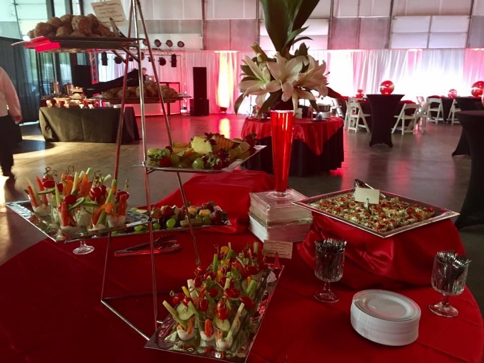 Catered corporate event buffet with appetizers and red table linens