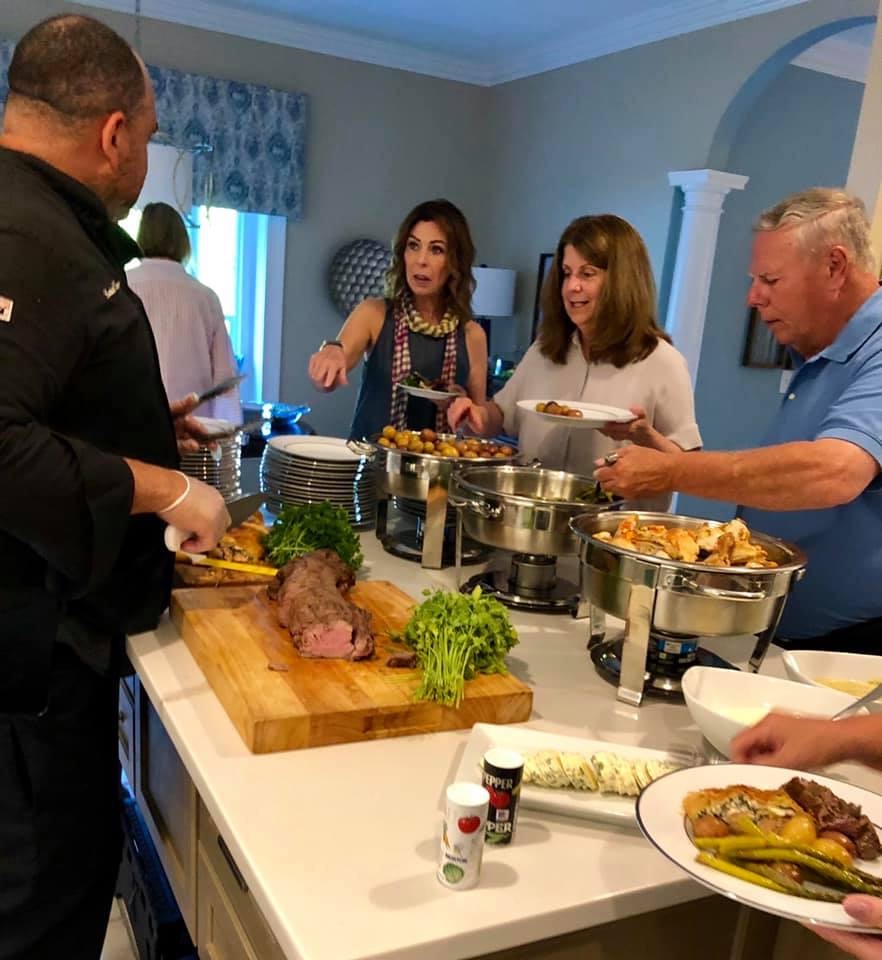 Catering staff serving guests at a social event buffet