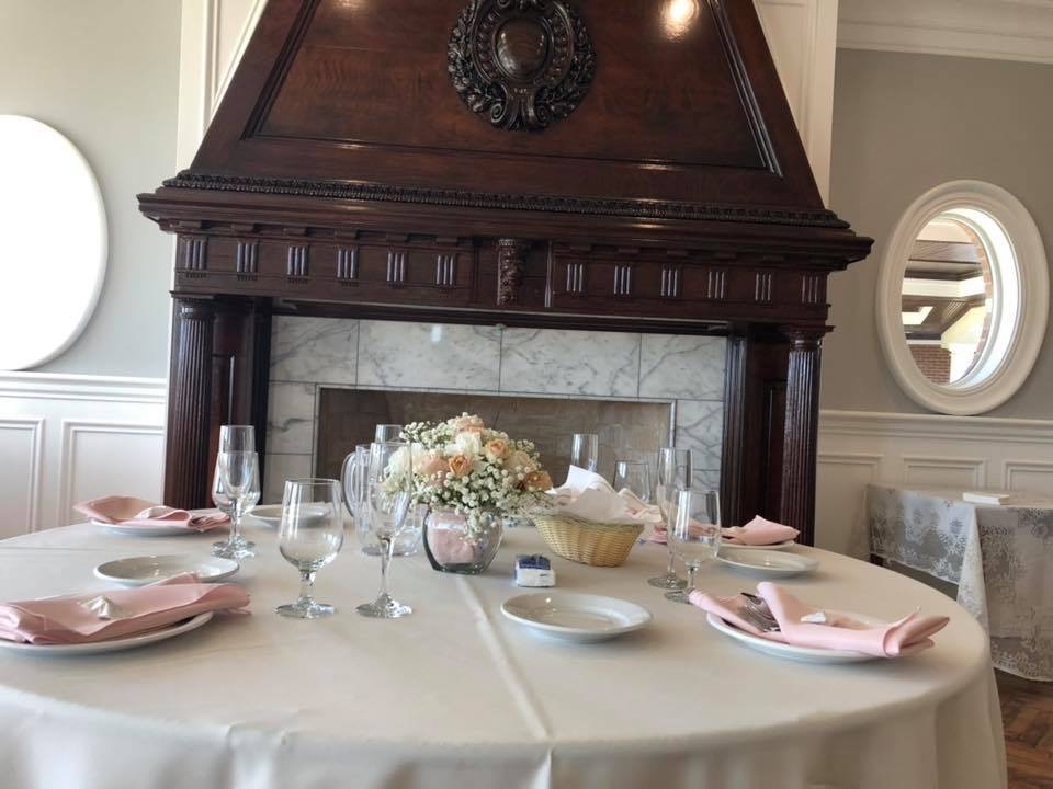 Elegantly set dining table with floral centerpiece and fireplace
