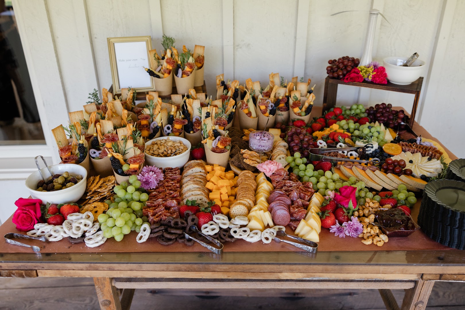Grazing table filled with charcuterie, cheeses, fruit, and crackers