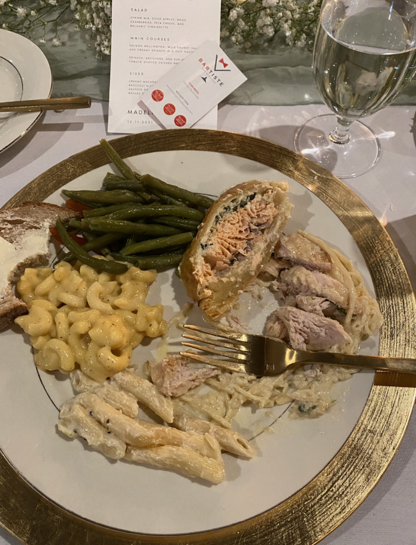 Catered meal served on a white plate with a gold rim